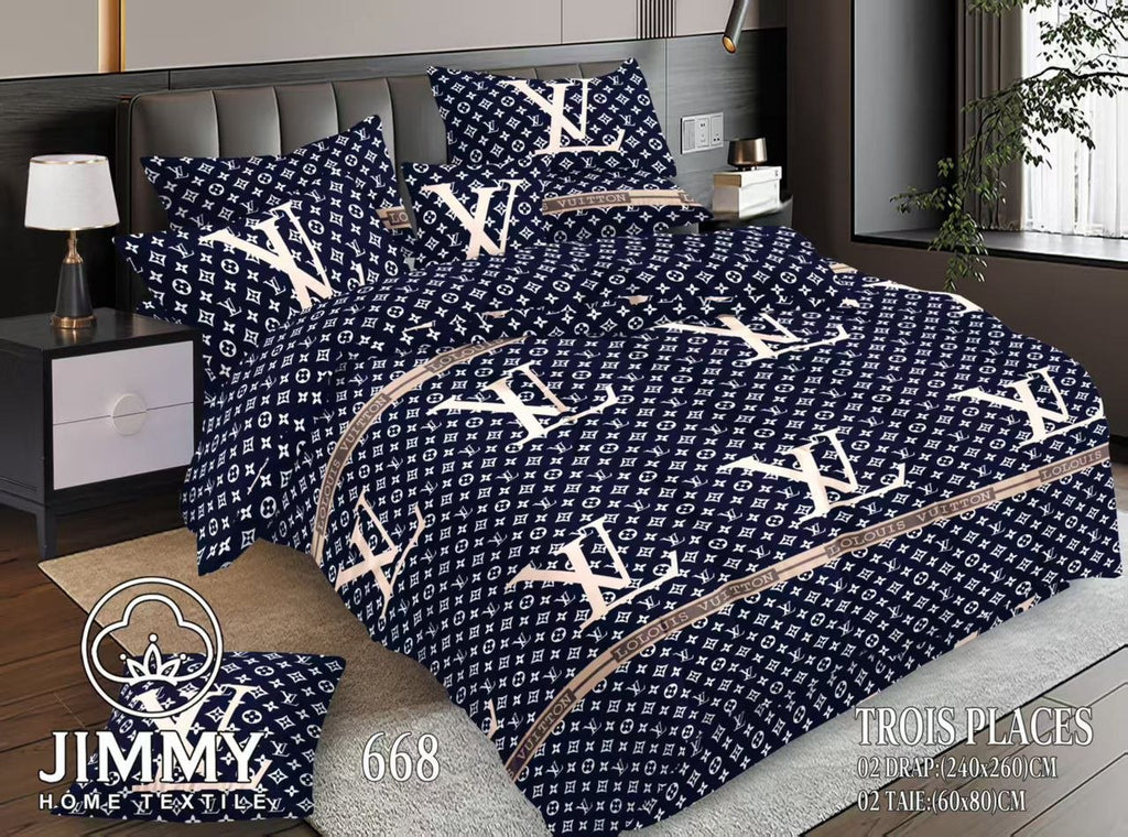 Ensemble de literie bleu marine avec motifs monogrammes blancs de la marque Jimmy Home Textile, comprenant deux draps de 240x260cm et deux taies d'oreiller de 60x80cm. Présentation sur un lit 'Trois Places' moderne, disponible à Bangui, République Centrafricaine chez 236 Shopping pour 10 990 FCFA
