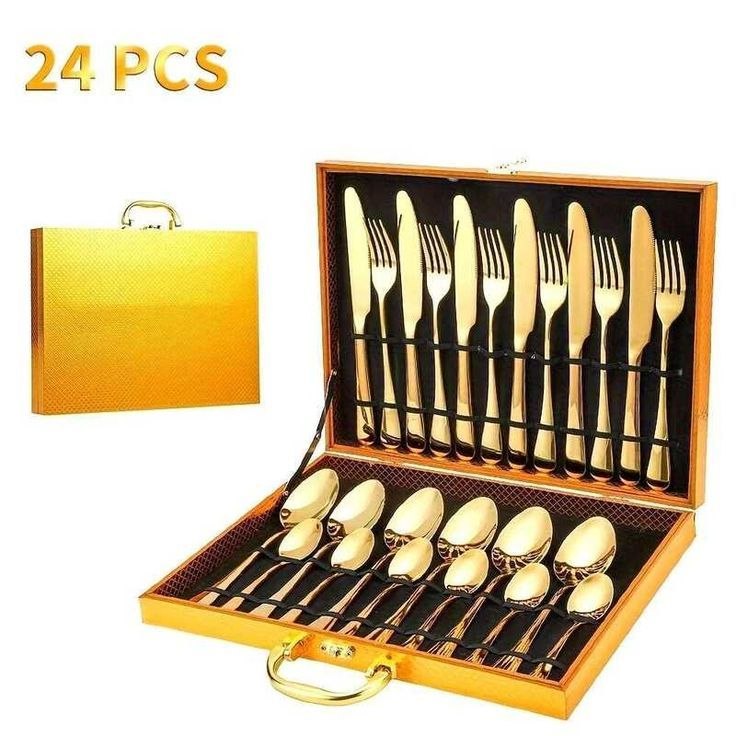 Ménagère complète de 24 pièces de couleur dorée comprenant des couteaux, des fourchettes et des cuillères, présentée dans une mallette de transport dorée élégante. Service de table de luxe disponible à Bangui, République Centrafricaine chez 236 Shopping pour 15 990 FCFA