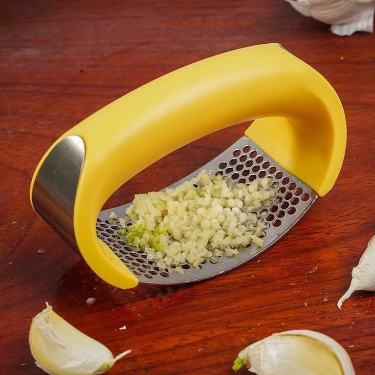 Ustensile de cuisine manuel pour presser l'ail et les légumes avec une grille en acier inoxydable et une poignée ergonomique noire. Accessoire de cuisine pratique présenté dans son emballage cadeau, disponible à Bangui, République Centrafricaine chez 236 Shopping pour 2 990 FCFA le lot de 2.