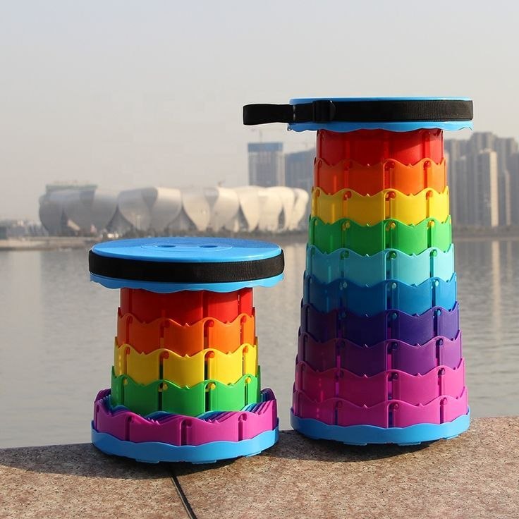 Tabouret télescopique rétractable avec un design en dégradé de couleurs arc-en-ciel, montré en position haute, intermédiaire et totalement replié sous forme de disque compact avec une sangle de transport noire. Accessoire disponible à Bangui, République Centrafricaine chez 236 Shopping pour 9 990 FCFA