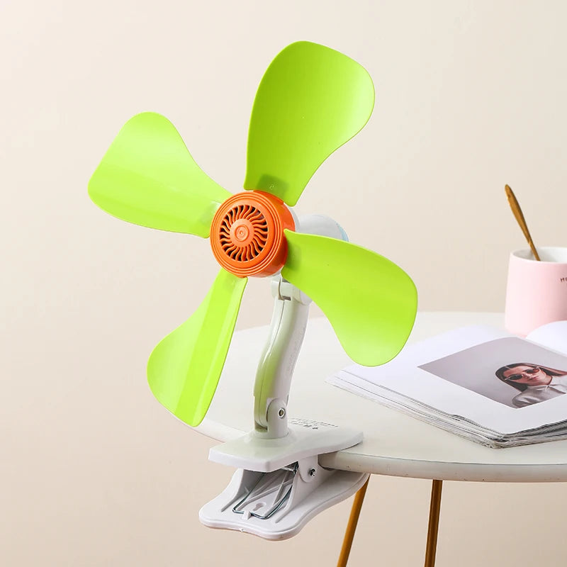Mini ventilateur portable vert et orange avec pince d'accroche (clip), idéal pour une utilisation sur un bureau ou à la maison.